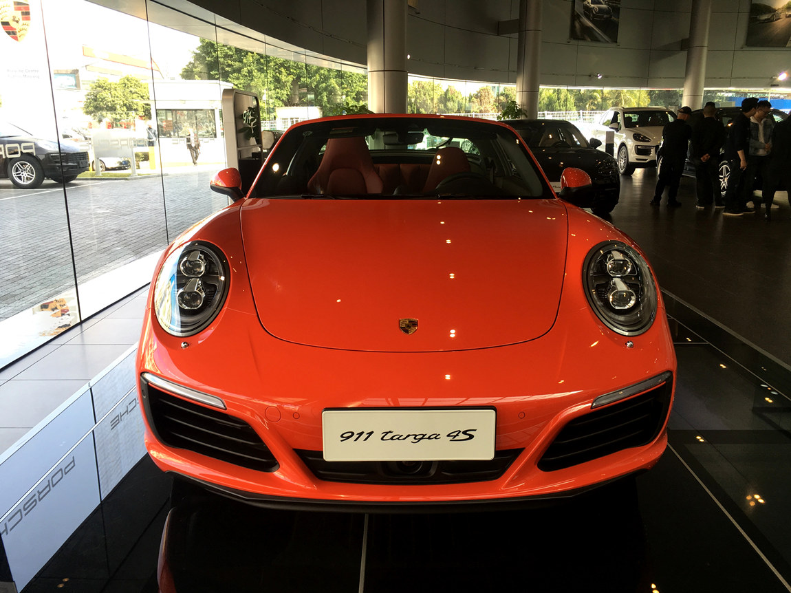 保时捷 911 Targa 4S 橙外红内 现车销售:车辆已备案,需要转籍。正规保时捷4S店全新车,车辆于2016年09月份生产,仪表里程20公里。车辆配置总价214.22万元,现车八五折销售,优惠后售价182万元。正规保时捷授权经销商全新商品车,享受保时捷官方质保售后及全国保修服务。 购买这款车需要走二手车过户流程,并且在车辆所在地上一手牌照,再提档回去。车还是新车,不过倒了一遍汽车手续,另外不能公司抵税。为什么要这么复杂,我简单和大家介绍下,这个车在豪华车消费税正式实施之前经过备案,备案的名字是4S店
